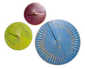 A set of three circular acrylic paintings in red, blue, and green colors, with a textured pattern and a central clock hand.